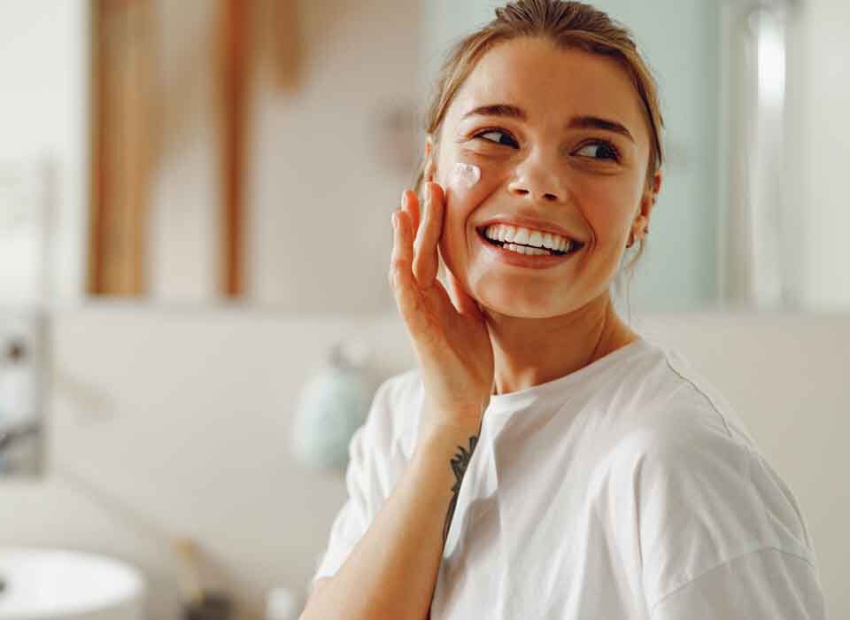 Mulher utilizando produtos para limpeza de pele