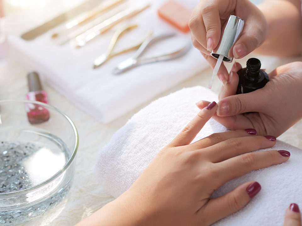 Mulher faz as unhas em salão de beleza com manicure