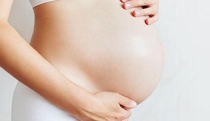 Mulher grávida com mãos na barriga