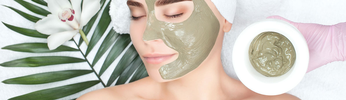Mulher deitada com máscara facial verde no rosto