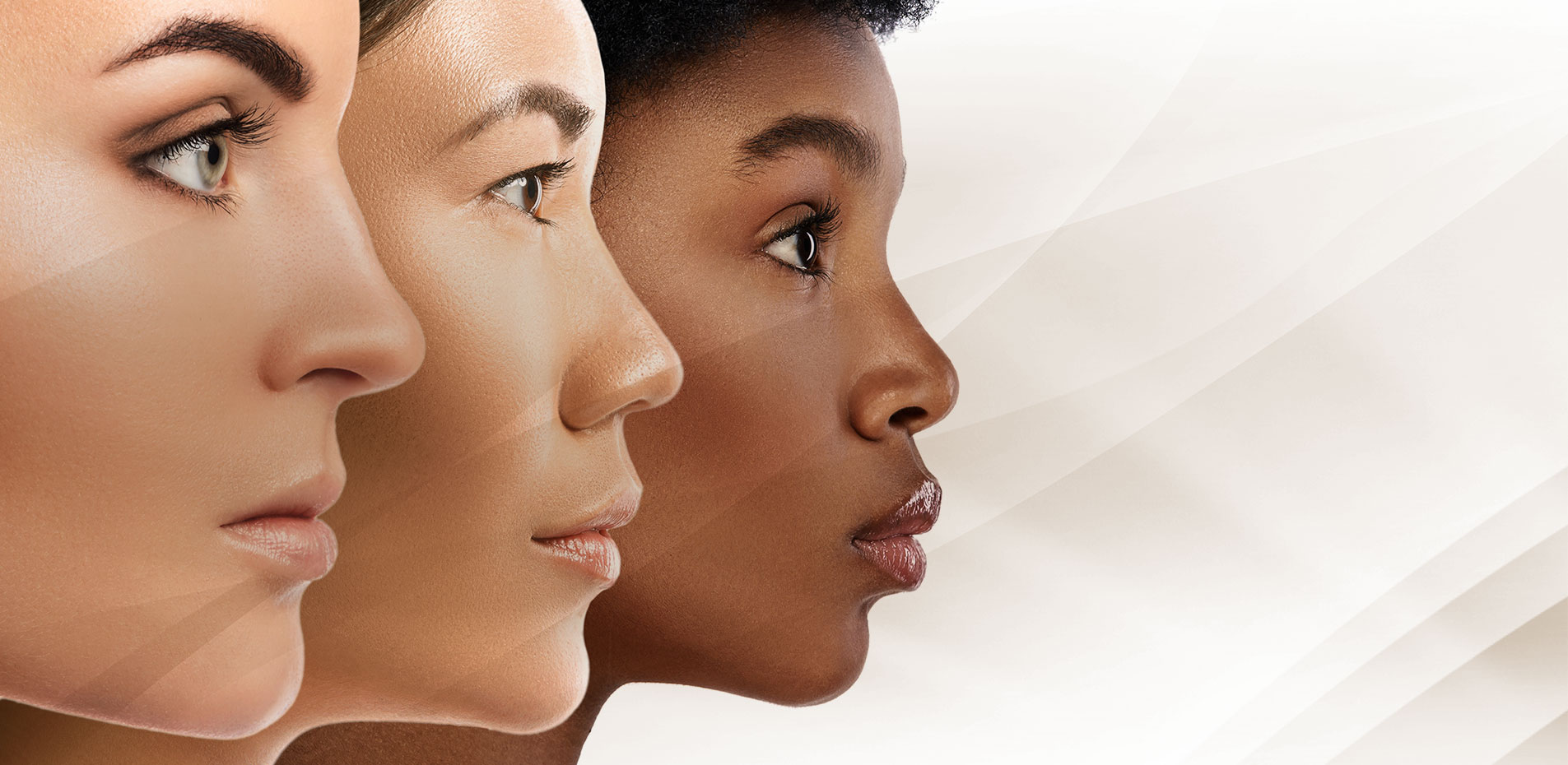 Perfil do rosto de três mulheres: uma branca, outra oriental e a terceira negra