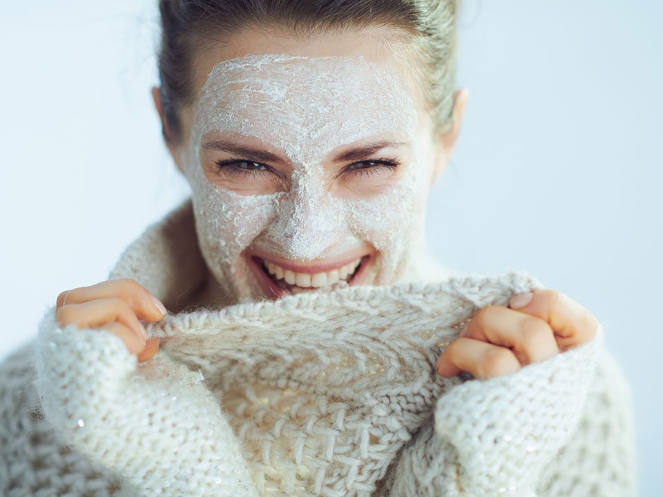 Mulher com creme no rosto reforçando hidratação no inverno
