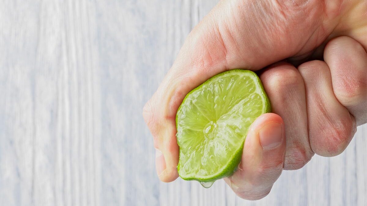 Mão apertando um limão