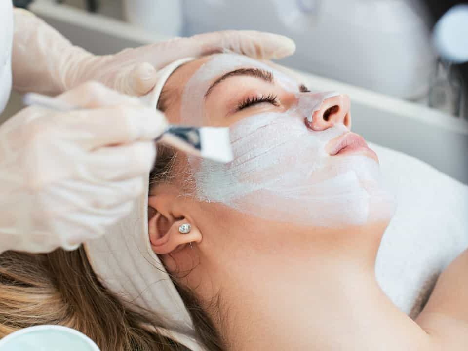 Esteticista fazendo tratamento de pele em rosto de mulher