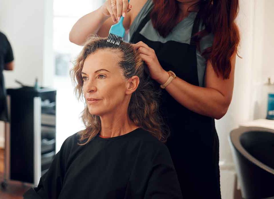 Mulher no cabeleireiro usando alisante