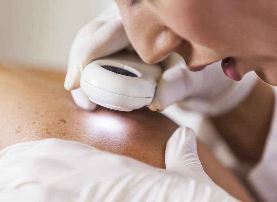 Dermatologista examinando paciente