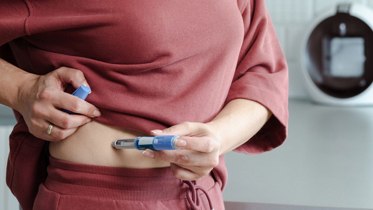 Mulher aplicando medicamento na barriga para perder peso