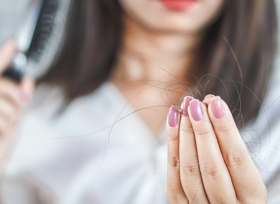 Mulher segurando mecha de cabelo
